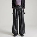 Black leather pants on an off-gray studio background