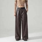 Coffee leather pants on an off-gray studio background