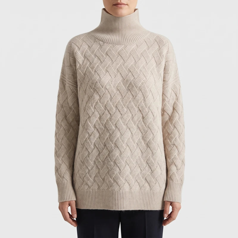 Woman wearing a natural beige cable-knit turtleneck sweater with a woven diamond pattern and ribbed trim over dark pants.