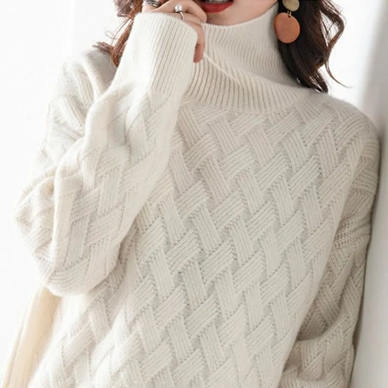 Woman wearing a close-up, off-white cable-knit turtleneck sweater with a distinct basketweave pattern and ribbed cuffs.