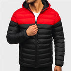 Man wearing a two-tone red and black hooded puffer jacket, partially zipping up the front.