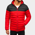 Man wearing a red and black color-block puffer jacket with a hood, red zipper, and side pockets.