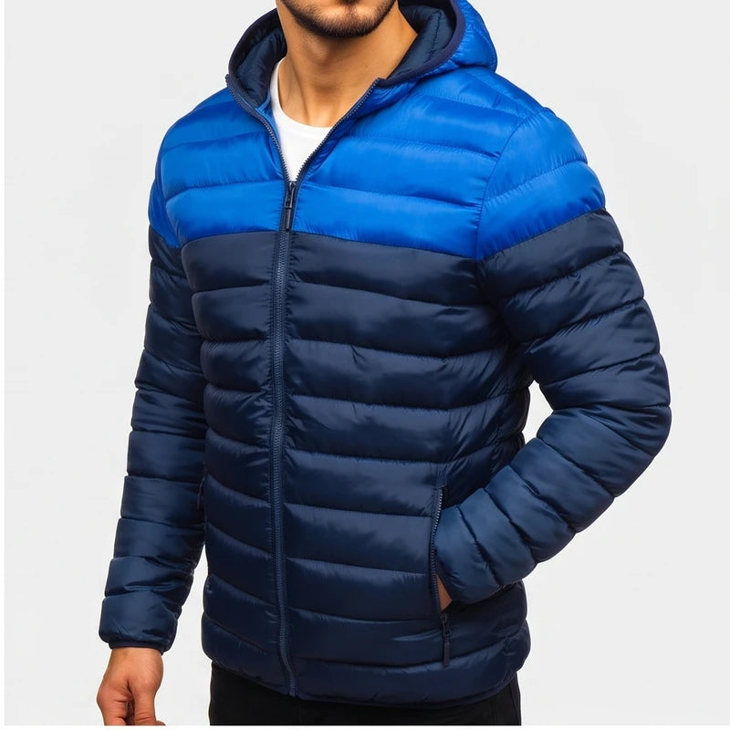 Man wearing a two-tone blue hooded puffer jacket, featuring a bright blue top and a dark navy blue bottom with horizontal quilting.
