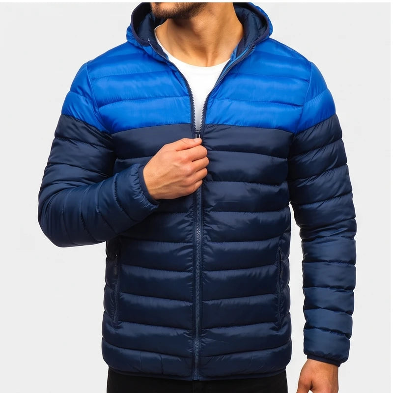 Man wearing a two-tone blue hooded puffer jacket with visible quilting, zipping up the front.