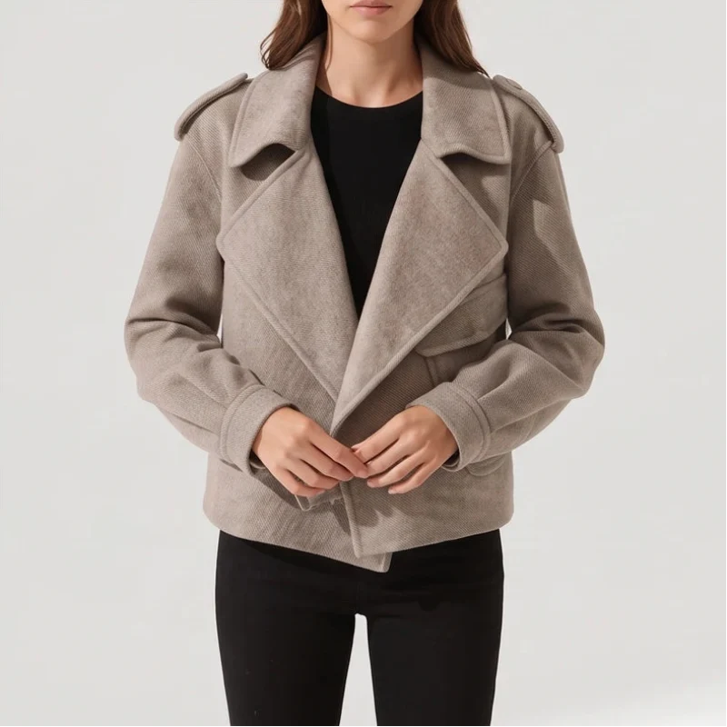 Woman wearing a light brown moto-style jacket with wide lapels, shoulder tabs, and two front pockets over a black top.