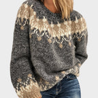 Woman wearing a fuzzy, loose-knit grey sweater with tan and cream geometric fair isle patterns across the chest and sleeves.