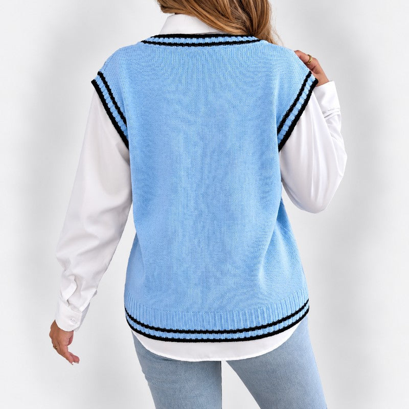 Woman wearing a light blue knit sweater vest with black and white striped trim over a white long-sleeve shirt, back view.
