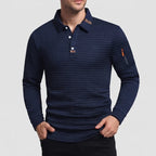 Man wearing a navy blue waffle-knit long-sleeve collared shirt with a three-button placket and arm zipper.