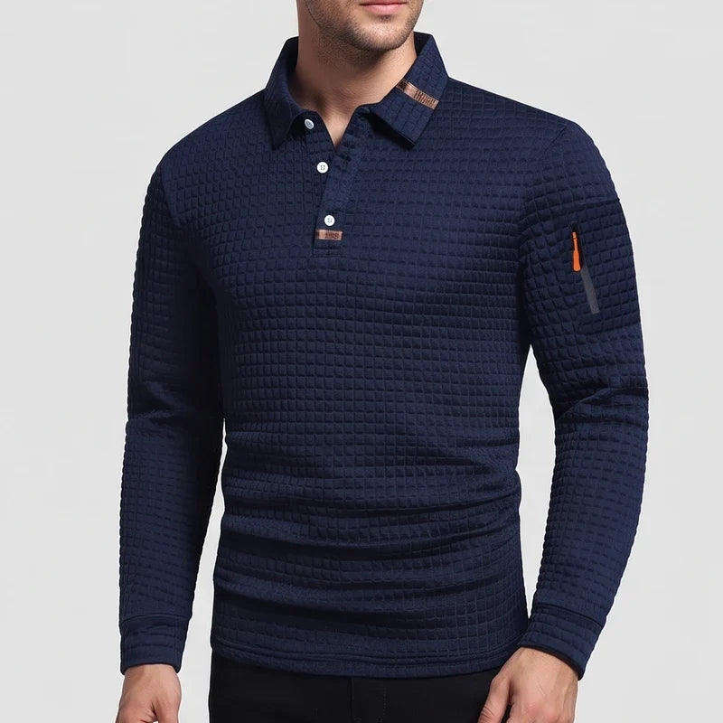 Man wearing a dark blue waffle-knit long-sleeve polo shirt with white buttons and an orange zipper pocket on the left arm.