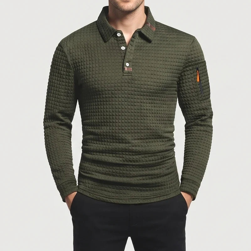 Man wearing a dark olive green long sleeve waffle knit polo shirt with a three-button placket and a zippered sleeve pocket.