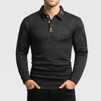 Man wearing a dark gray long sleeve polo shirt with a quilted texture and a small zippered pocket on the left arm.