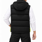 Man wearing a black puffer vest with horizontal baffles and a hood, standing with one hand in his pocket.