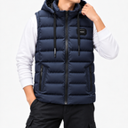 Man wearing a navy blue hooded puffer vest with black zippers and side pockets over a white long-sleeve shirt.