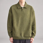 Man wearing an olive green long-sleeve polo shirt with a subtle diagonal textured pattern and a single white button.