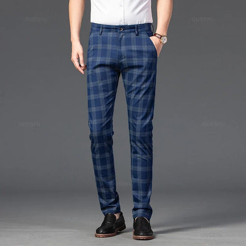 Man wearing blue plaid straight-leg trousers with thin gray checks, a white shirt, brown watch, and black loafers.
