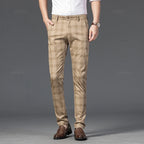 Man wearing slim-fit beige trousers with a brown plaid pattern, paired with a white shirt and brown loafers.