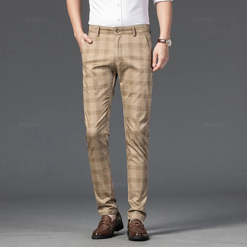 Man wearing slim-fit beige trousers with a brown plaid pattern, paired with a white shirt and brown loafers.