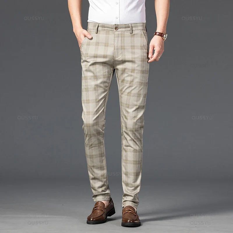 Man wearing light beige straight-leg trousers with a subtle brown plaid pattern, standing with one hand in a pocket.