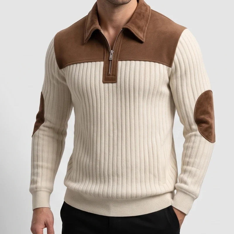 Man wearing a cream ribbed knit quarter-zip jumper with brown suede collar, shoulder yoke, and elbow patches over black pants.