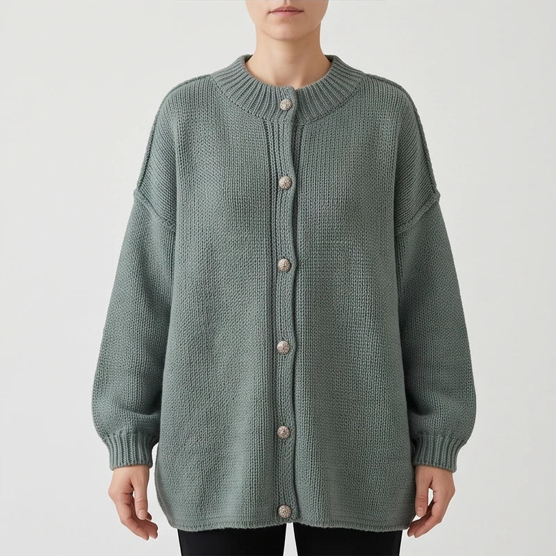 Woman wearing an oversized sage green knit cardigan with ribbed collar, cuffs, and silver-tone buttons, on a white background.