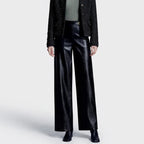 Black leather pants on an off-gray studio background