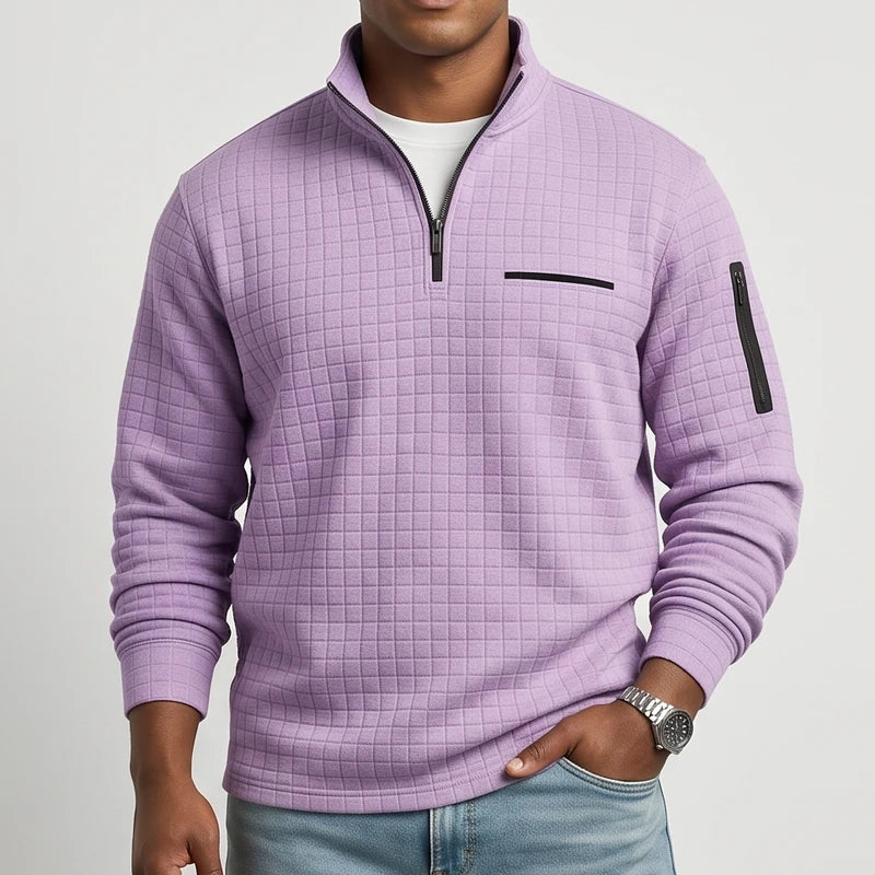 Man wearing a lilac textured quarter-zip jumper with a black chest pocket detail and a black zippered arm pocket.