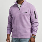 Man wearing a lilac purple quarter-zip waffle knit jumper with black chest and sleeve zipper pockets.