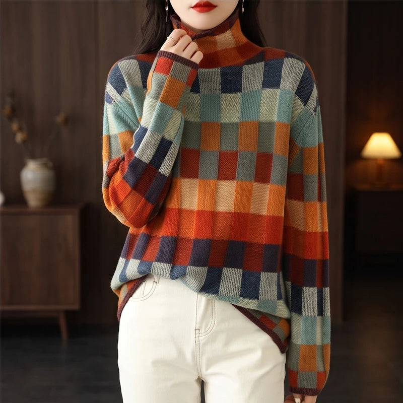 Woman wearing a colorful checked turtleneck sweater with a high collar, paired with cream trousers, in a room with a warm lamp.