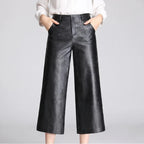 Black leather pants on an off-gray studio background
