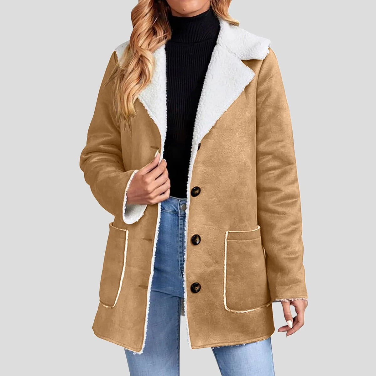 Woman wearing a tan suede-feel jacket with white borg lining, exposed collar, three dark buttons, and two patch pockets.