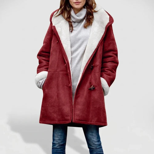 Woman wearing an open red suede coat with a white borg lining and toggle closures, over a gray turtleneck sweater and jeans.