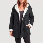 Woman wearing an open black hooded coat with white borg lining, toggle closures, and her hand in a pocket.