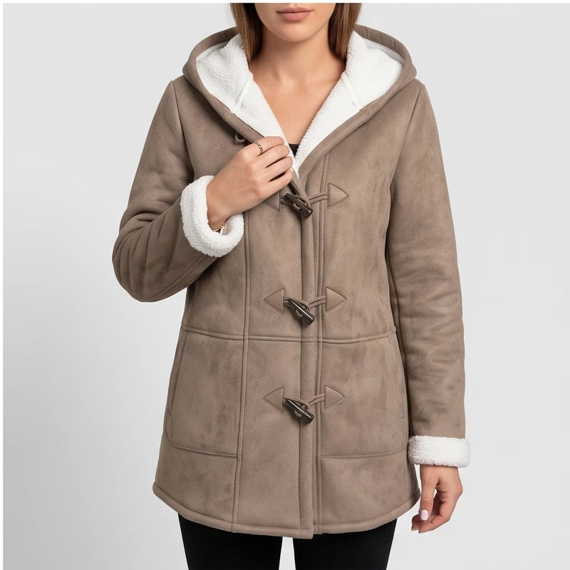 Woman wearing a taupe faux suede coat with a white borg-lined hood and cuffs, featuring toggle fasteners.