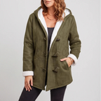 Woman wearing an olive green hooded jacket with a white borg lining, dark toggle closures, and a hand in a side pocket.