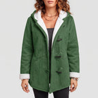 Woman wearing a green suede-like hooded coat with white sherpa lining, black toggle closures, and cuffs rolled up.