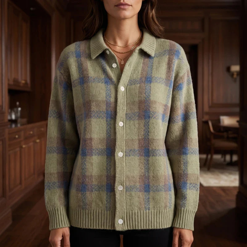 Woman wearing a collared, button-front cardigan in an olive, blue, and brown plaid pattern, standing in a wood-paneled room.