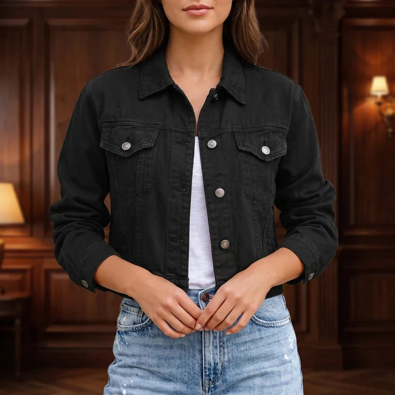 Woman wearing a dark gray cropped denim jacket with silver buttons over a white top and light wash jeans.