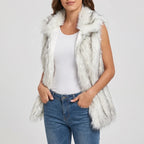 Woman wearing a gray and white fluffy vest with a wide collar, light blue jeans, and a white t-shirt.