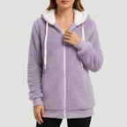 Woman wearing a lavender plush fleece full-zip hoodie with a white hood lining and white drawstrings, posing indoors.