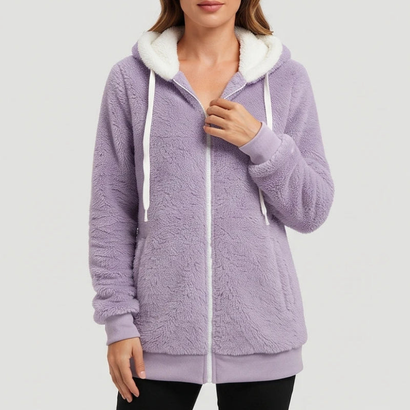 Woman wearing a lavender plush fleece full-zip hoodie with a white hood lining and white drawstrings, posing indoors.