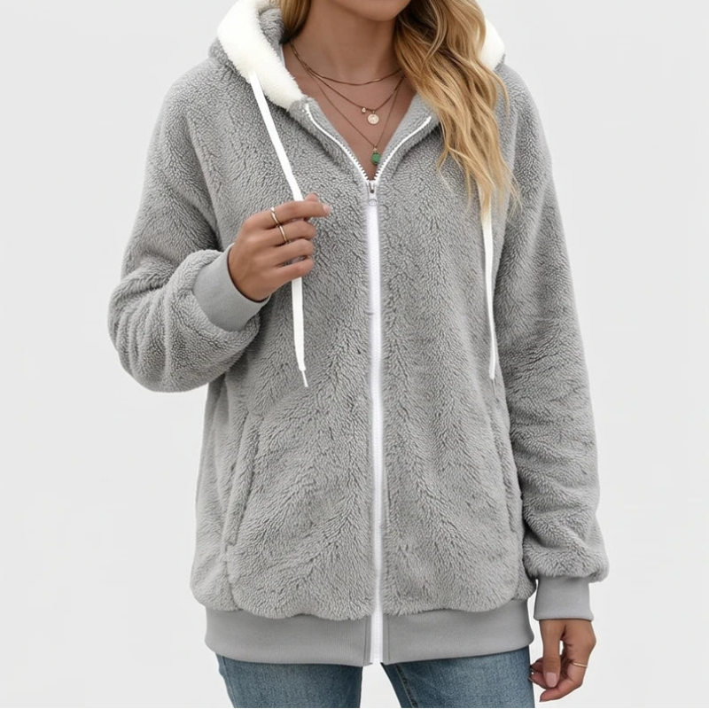 Woman wearing an open gray fuzzy zip-up hoodie with a white hood lining, white drawstrings, and ribbed cuffs.