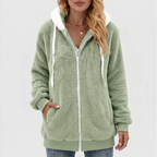 Woman wearing a fluffy light green full-zip hoodie with white drawstrings and a contrasting white hood lining.