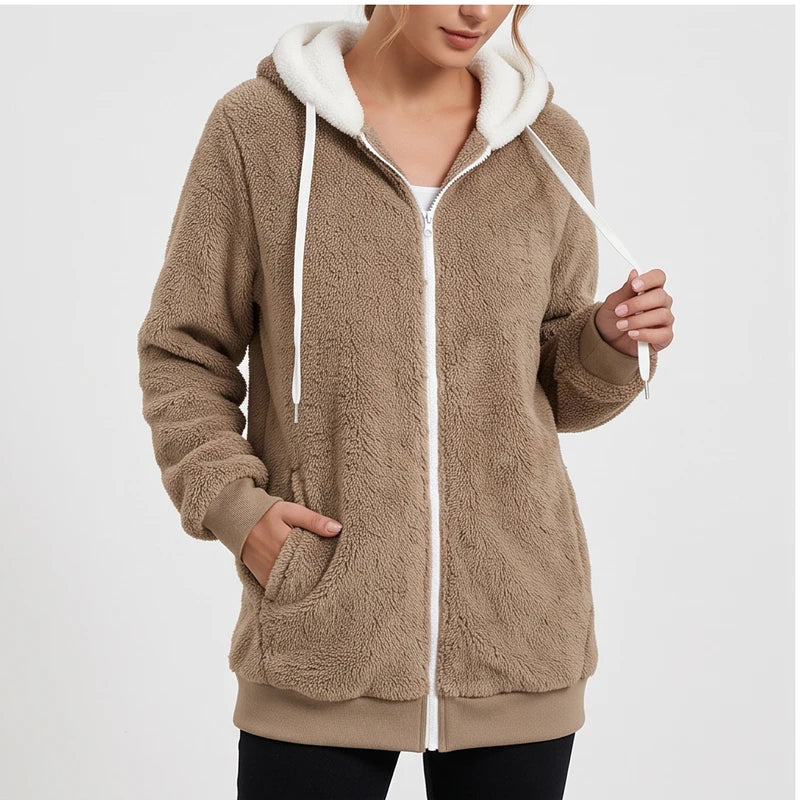 Woman wearing a plush brown fleece hoodie with a white zipper, white drawstring, and front pockets, against a light background.