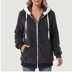 Woman wearing a dark gray fluffy fleece zip-up hoodie with a white zipper, white drawstring, and white hood lining.