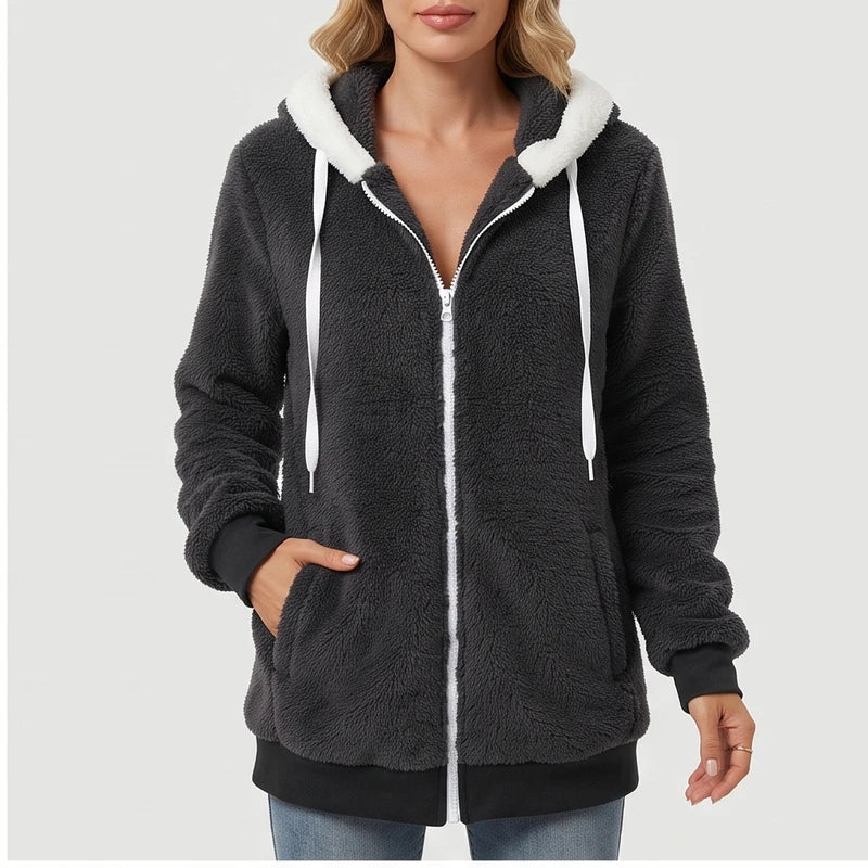 Woman wearing a dark gray fluffy fleece zip-up hoodie with a white zipper, white drawstring, and white hood lining.