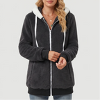 Woman wearing a dark gray fluffy fleece hoodie with a white zipper, white drawstring, and white hood lining.