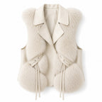 Flat lay of a cream vest with a wide lapel collar, soft faux fur trim, and leather-like ties.