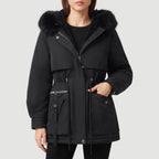 Woman wearing a black parka coat with a black faux fur hood, internal sherpa lining, and adjustable waist drawstring.