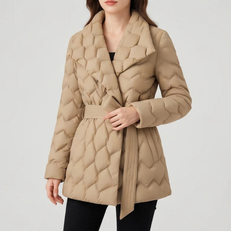 Woman wearing a light brown quilted puffer coat with a wide collar and a matching tie belt at the waist.