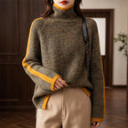 Woman wearing a mottled dark green and yellow ribbed knit roll neck jumper with yellow stripes on the sleeves.